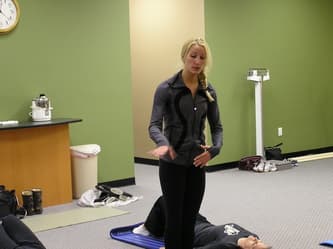 CWC Gym instructor leading a stretching exercise during a fitness class