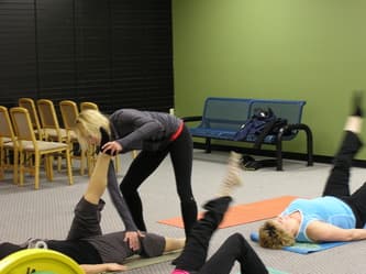 CWC Gym members stretching on mats during a fitness class