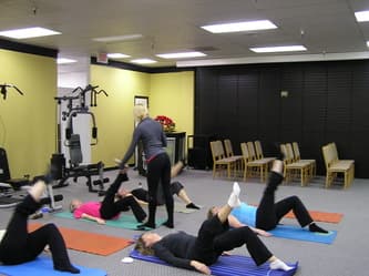 CWC Gym instructor guiding members through floor exercises on mats